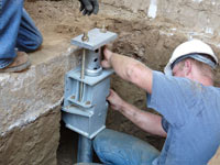 Foundation repair contractors installing the foundation bracket in McKeesport.