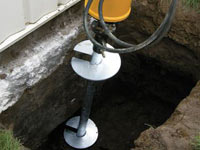 Installing a helical pier system in the earth around a foundation in Bethel Park