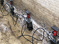 Using foundation push piers to lift a foundation during a repair in New Castle.