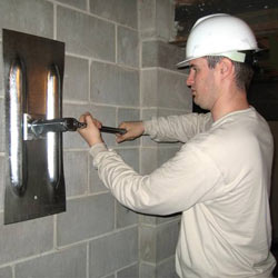 installing a wall anchor to repair an bowing foundation wall in New Castle